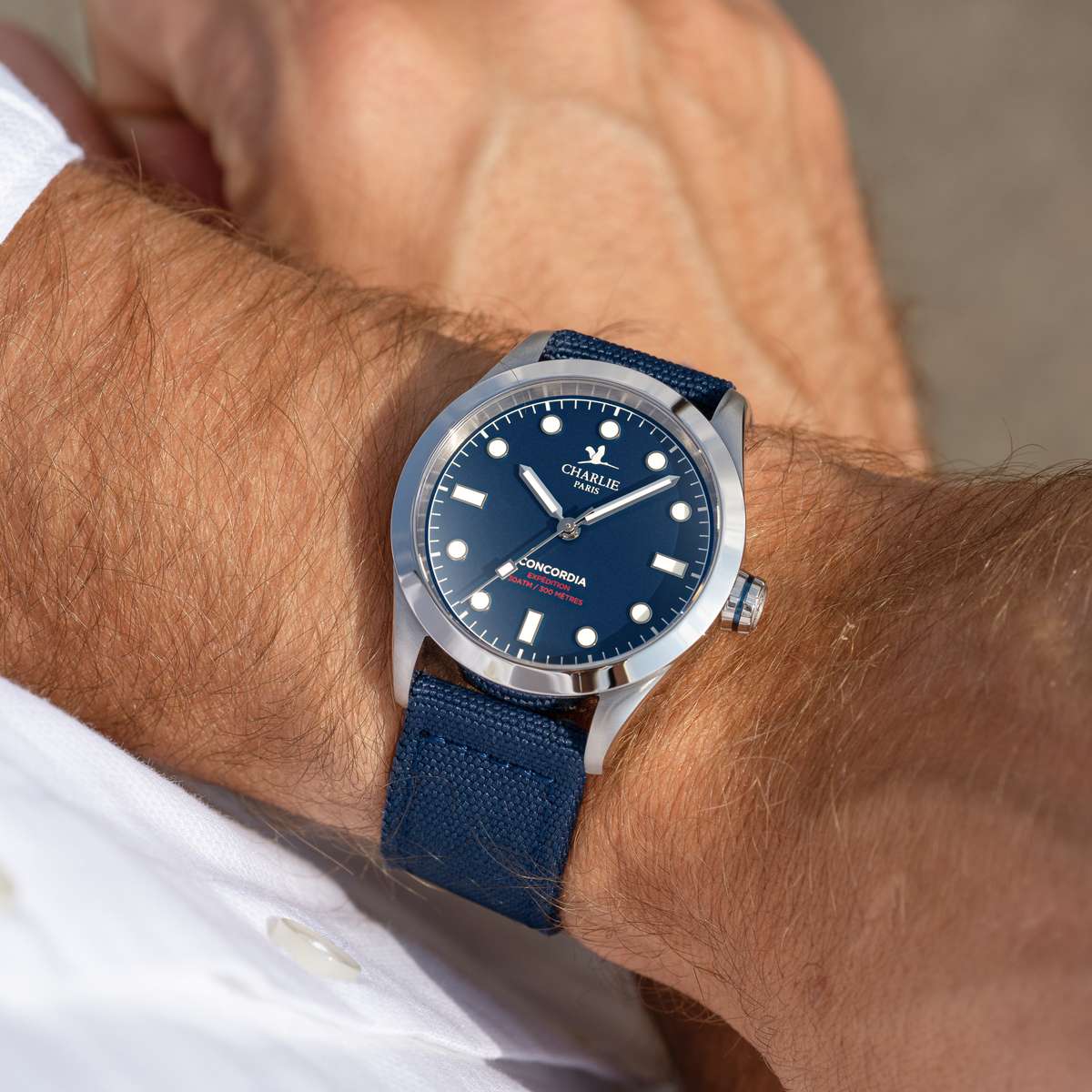 Gros plan sur le poignet d’un homme arborant le modèle de montre quartz étanche pour homme Concordia avec cadran bleu